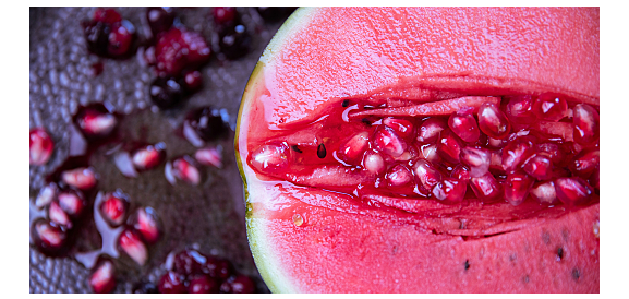 cocomero aperto da cui escono chicchi di melograno