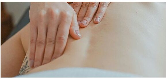 mano di donna massaggia schiena