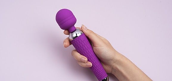 mano e vibratore su sfondo rosa