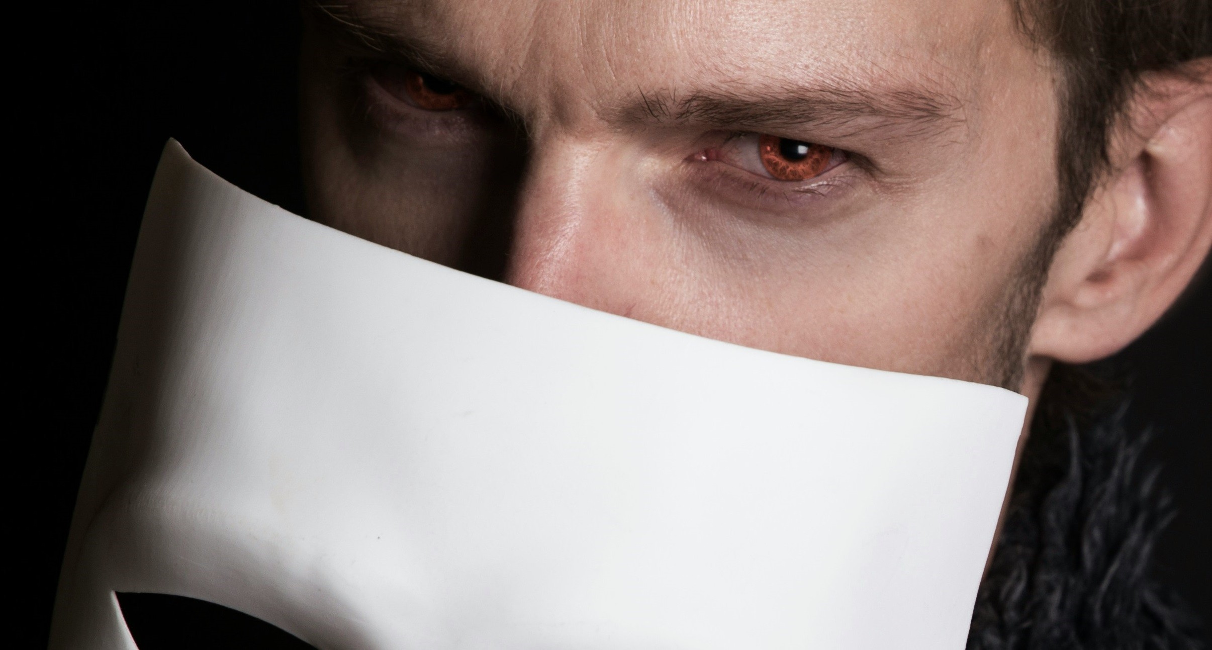 uomo con occhi rossi e maschera